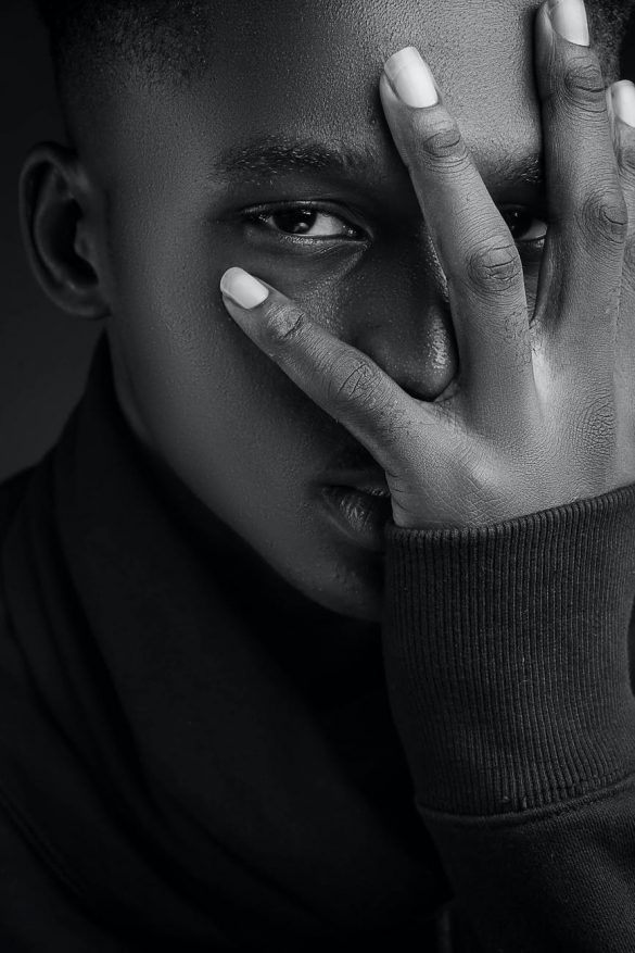 black man covering face with hand